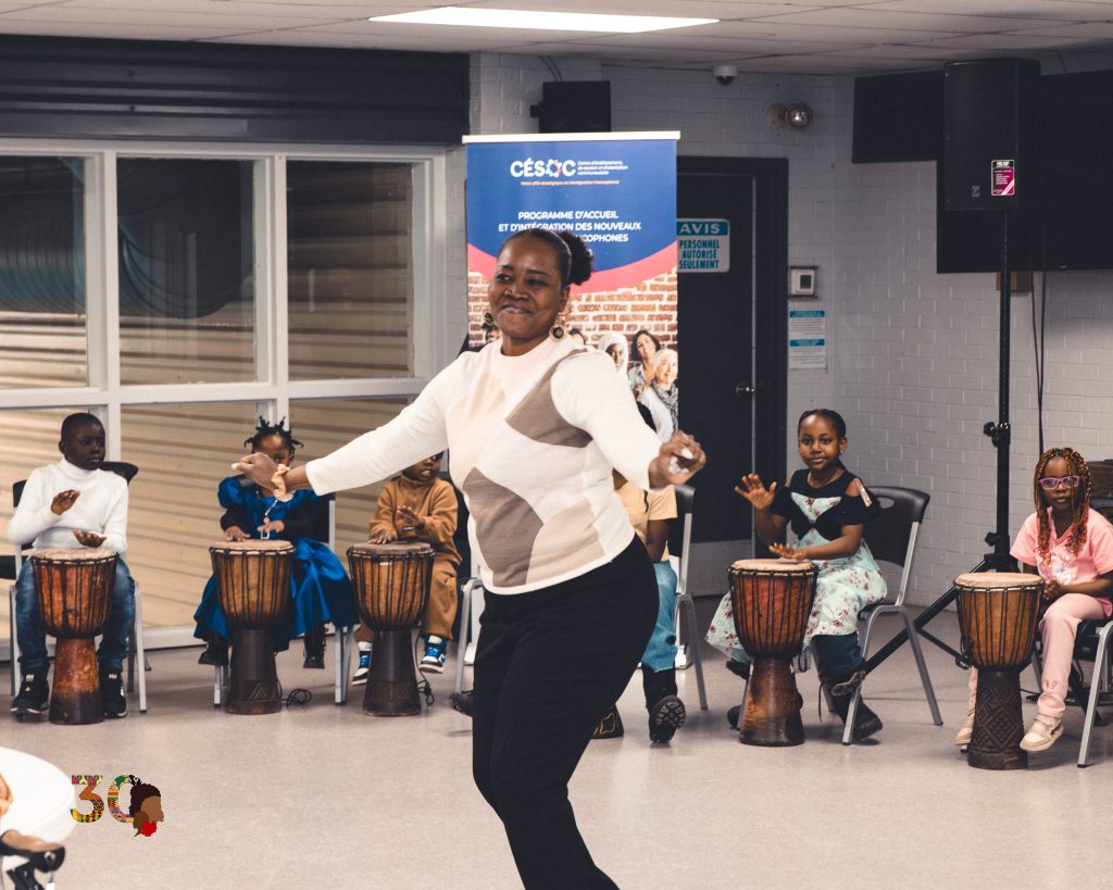 Atelier participatif au djembé : une animatrice danse pendant que des enfants jouent des percussions à Hawkesbury.